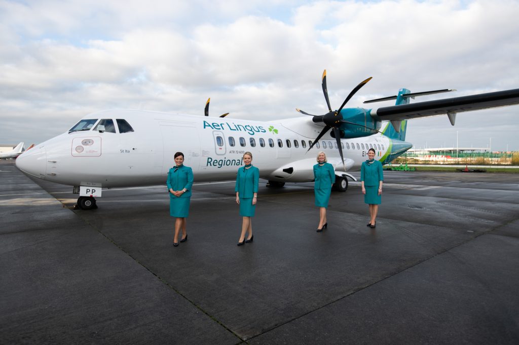Emerald Airlines cabin crew standing outside Aer Lingus aircraft