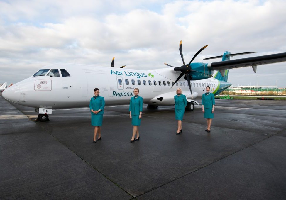 Emerald Airlines cabin crew standing outside Aer Lingus aircraft